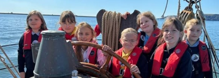 Marine Academy Pupils on a sailing boat, at the helm
